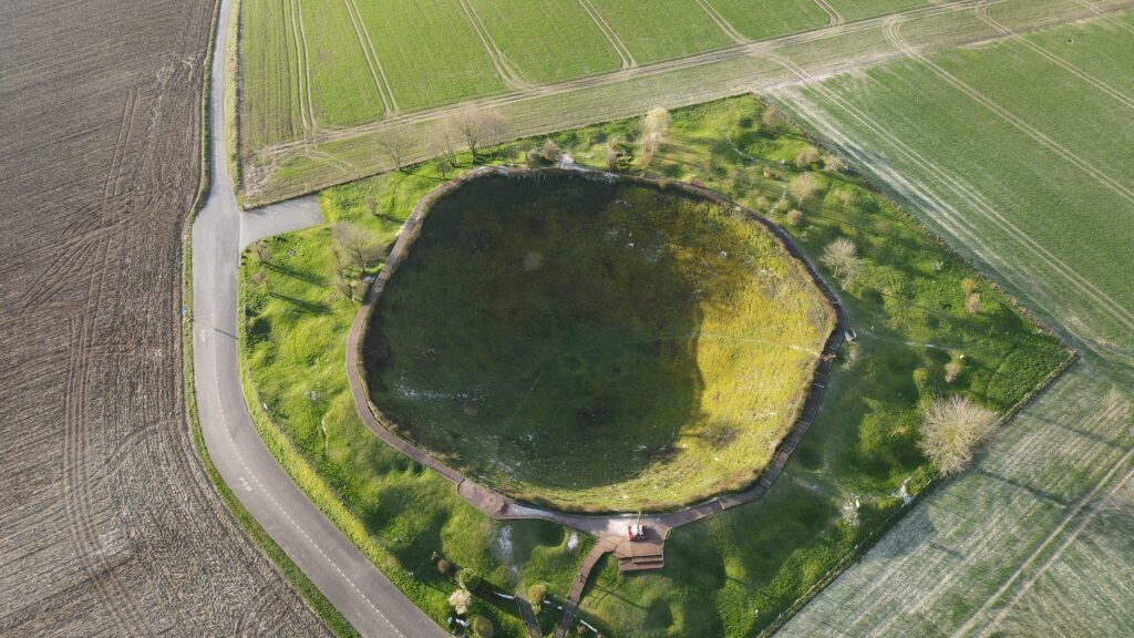 Luftaufnahme des Lochnagar-Kraters mit umlaufendem Holzsteg inmitten der Felder bei La Boisselle, Frankreich.